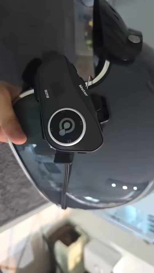 Photo client : le boîtier fixé sur un casque intégral noir